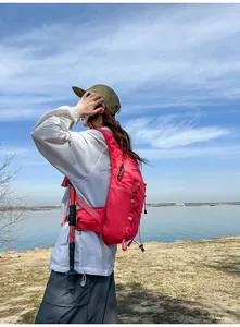 Escursionista indossa uno zaino rosso leggero da outdoor vicino a un lago scenico