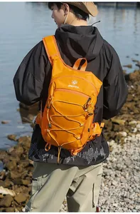 Zaino da trekking arancione leggero indossato da un modello per escursioni e ciclismo.