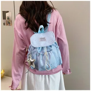 Young woman wearing a light blue star-patterned mini backpack in a casual setting