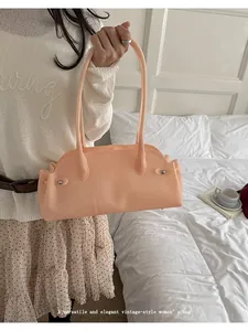 Bolso baguette vintage melocotón para mujer mostrado en un ambiente de dormitorio