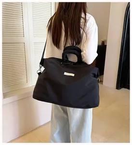 Dettaglio di una grande borsa sportiva nera indossata come borsa a tracolla da un modello