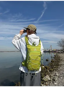 Dettaglio dello zaino da trekking ultraleggero verde lime in un ambiente naturale all'aperto.