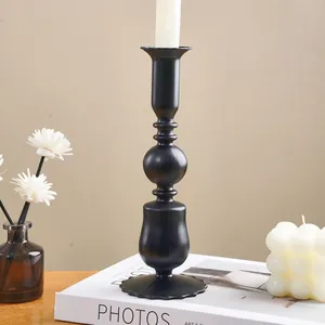 Elegant vintage black candle holder displayed on a book for romantic table decor