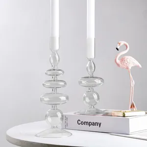 Vista dettagliata di eleganti candelabri in vetro trasparente su tavolo bianco