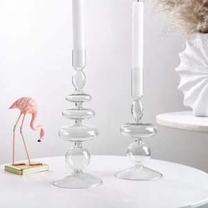 Vista dettagliata di due eleganti candelabri geometrici in vetro su una scrivania bianca