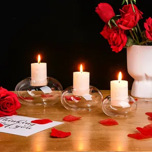 Nahaufnahme von eleganten Glaskerzenhaltern mit roten Rosen für romantische Dekoration.