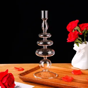 Elegante candeliere in vetro a più livelli su un vassoio di legno con vivaci rose rosse