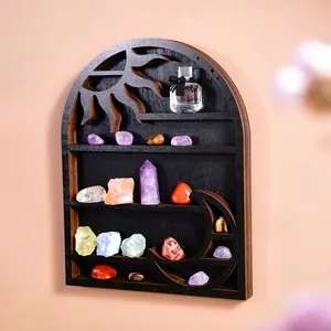 Artistic black wooden sun and moon wall shelf displaying colorful crystals and perfume.