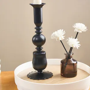 Elegant black vintage metal candle holder detail on a wooden tray with white flowers