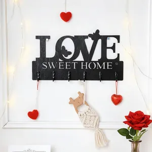 Detailansicht der dekorativen schwarzen LOVE-Wandhakenleiste aus Holz für das Zuhause