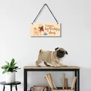 Decorative wooden pug birthday sign hanging in a cozy modern home with a real pug