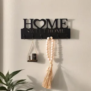 Schwarze Wandhakenleiste aus Holz mit 'HOME SWEET HOME'-Design an einer Wand