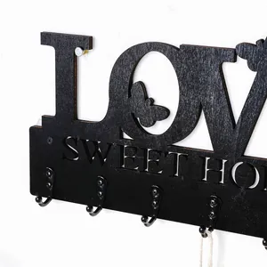 Detailansicht Schlüsselbrett aus schwarzem Holz mit 'LOVE' und 'SWEET HOME' Ausschnitt