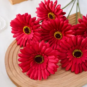 Vista detallada de margaritas gerbera rojas artificiales para decoración floral del hogar.
