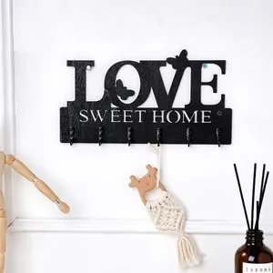 Detailansicht einer schwarzen Wandhakenleiste aus Holz mit LOVE und SWEET HOME Design