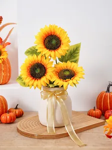 Lebendiger künstlicher Sonnenblumenstrauß in weißer Vase mit Erntedankfest-Kürbisdeko.