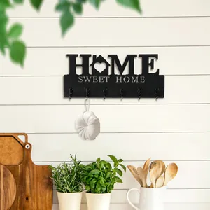 Dekorativer Wandhaken aus schwarzem Holz mit Schriftzug HOME SWEET HOME in der Küche