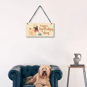 Cute wooden pug birthday hanging sign displayed in a cozy living room wall setting