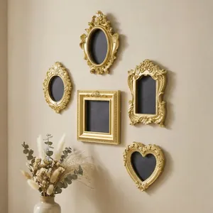 Detailed view of ornate gold vintage resin frames set on wall with dried flowers prop