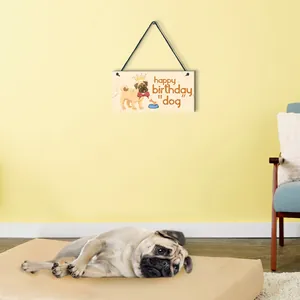 Close-up of a decorative wooden dog sign featuring a pug and 'happy birthday' text