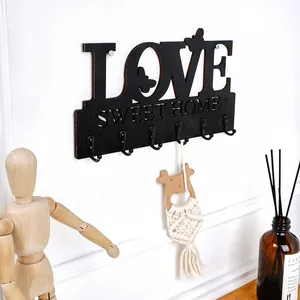Detail der hölzernen Wandhakenleiste "LOVE SWEET HOME" für Schlüssel und Deko.