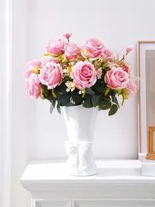 Close-up of pink artificial roses in a white bow vase for wedding decor