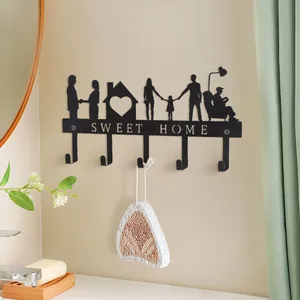 Detailaufnahme des schwarzen Metall-Wand-Schlüsselhakens mit Familiensilhouette an beigefarbener Wand.