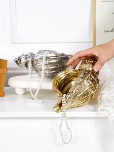Detailed view of gold and silver shell-shaped resin vases for creative home decor.