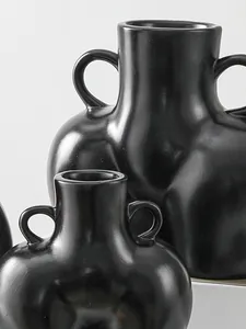 Detalle del acabado negro mate y las asas del jarrón artístico de resina con forma de cuerpo