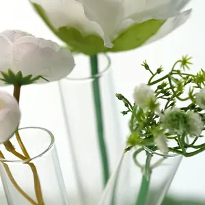 Macrodetail van creatieve transparante glazen vaas met drie buizen en mooie bloemen