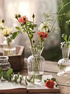 Detailaufnahme einer gerippten Glasvase mit frischen Rosen auf einem Holztisch