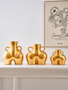 Detalle de jarrones de resina dorada con asas dobles de estilo minimalista nórdico