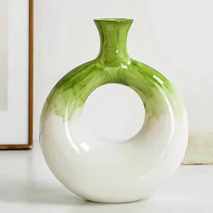 Primo piano di un vaso in resina a forma di ciambella con dettagli verdi dipinti a mano