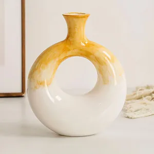 Dettaglio di un creativo vaso a ciambella in resina con finitura dipinta a mano gialla e bianca