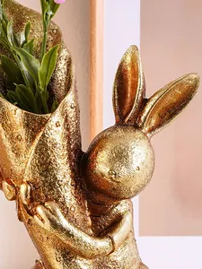 Close-up macro detail of a golden resin rabbit flower vase with textured metallic finish
