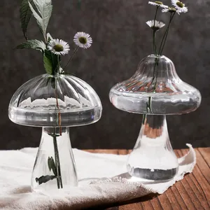 Gedetailleerde weergave van twee creatieve paddenstoelvormige glazen vazen voor decoratie