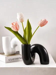 Vase artistique en résine courbé en forme de U noir et blanc avec de belles tulipes