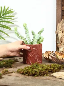 Nahaufnahme eines braunen Harz-Blumentopfs im nordischen Stil mit Blattrelief-Muster