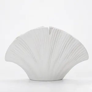 Detailopname van een moderne minimalistische witte vaas met textuur van ginkgoblad