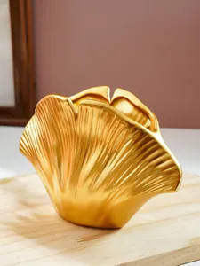 Macro-weergave van de gedetailleerde textuur en gouden afwerking van de schelpvormige harsvaas