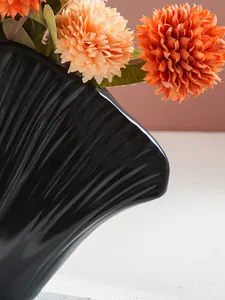 Detailopname van de elegante schelpachtige textuur van een moderne zwarte vaas van hars