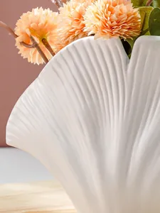 Detail van de witte schelpvormige harsvaas met een elegante radiale geribbelde textuur
