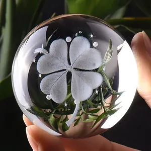 Macro view of a laser engraved crystal ball featuring a delicate four-leaf clover design.