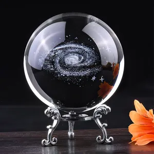 Detailed view of clear crystal ball with laser-engraved galaxy inside on ornate stand