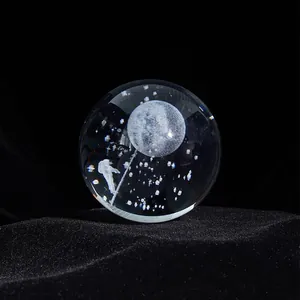 Detailed macro view of laser engraved astronaut and moon inside clear crystal ball