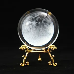 Detailed laser-engraved moon inside a clear crystal ball on a golden ornate stand
