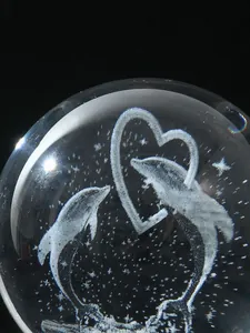 Macro detail of laser engraved glass crystal ball with dolphin heart and stars