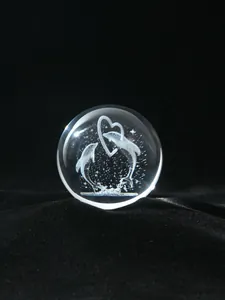 Macro view of laser-engraved crystal ball featuring a dolphin and heart design