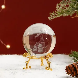 Primer plano de bola de cristal grabada con láser 3D con muñeco de nieve en soporte