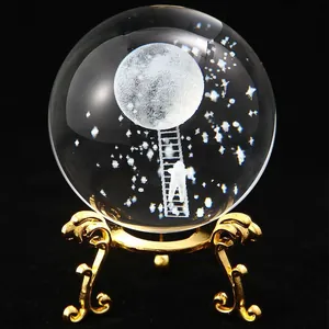 Detail view of 3D laser-engraved moon and stars inside a clear crystal ball ornament